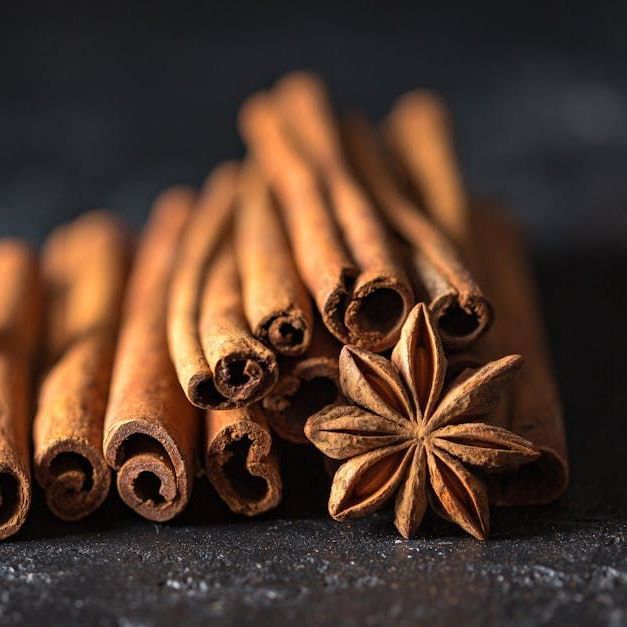 A pile of cinnamon sticks and star anise on a table