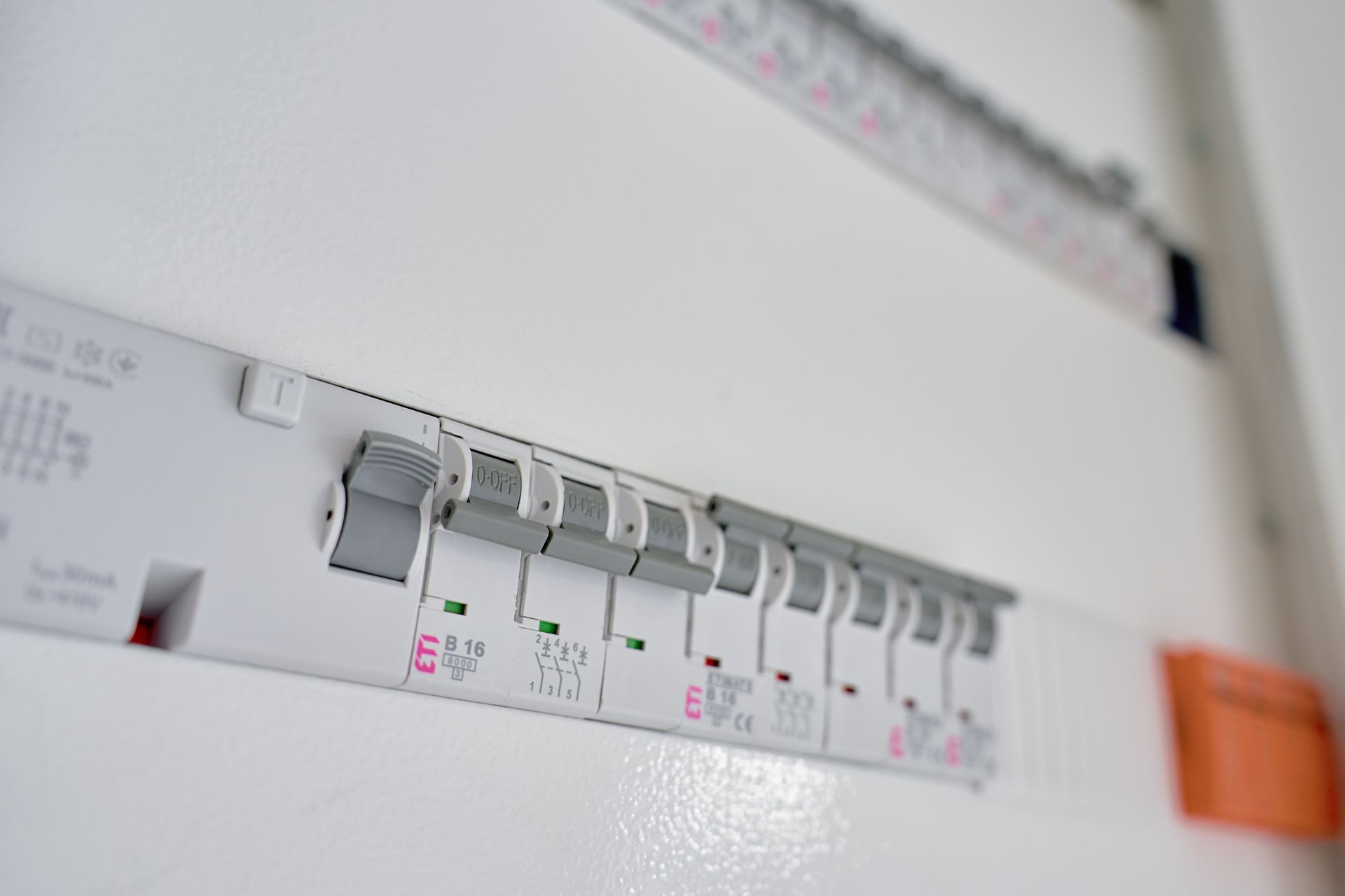 White electrical fuse box with various circuit breakers in the on position.