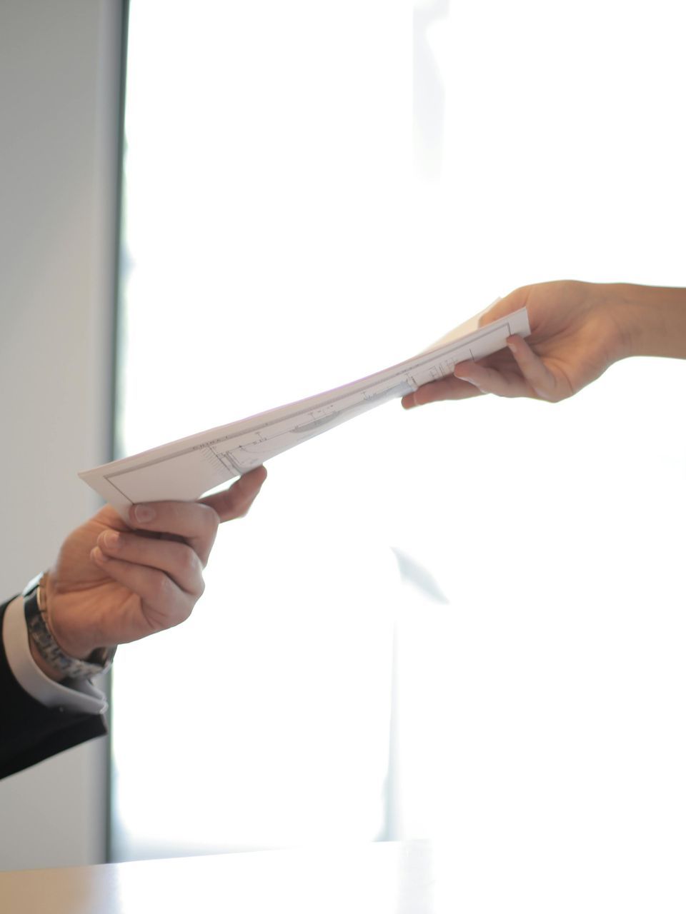 A man is handing a piece of paper to a woman.