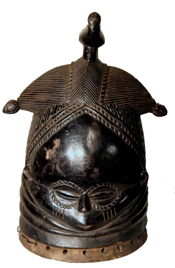 A dark, carved wooden Mende Sowei helmet mask with a high, intricate coiffure, stylized face, and holes along the base.