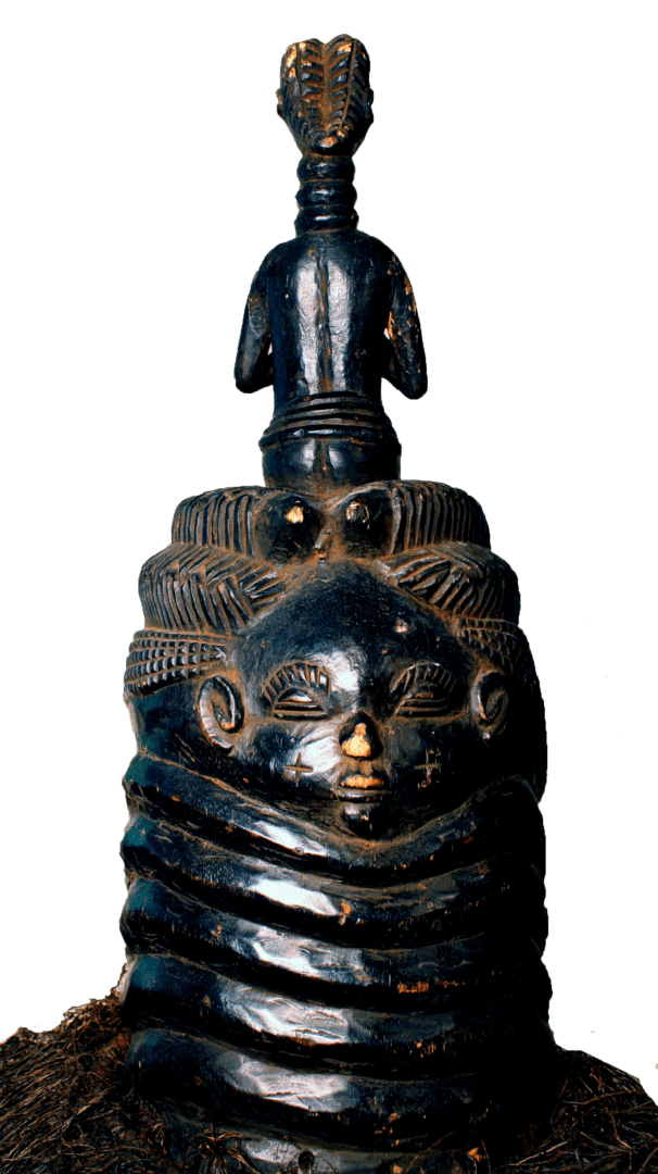 A dark, carved wooden Mende Sowei helmet mask with a serene face, ringed neck, and a small standing figure on top.