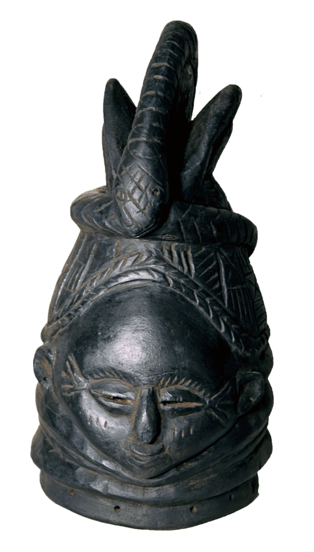 A dark, carved wooden helmet mask featuring a stylized face and an ornate crest with a snake coiling around the top.