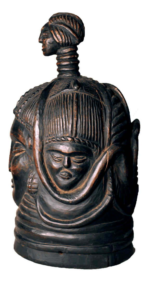 A dark, carved wooden helmet mask featuring multiple faces and a smaller, distinct head on a ringed neck at the crown.