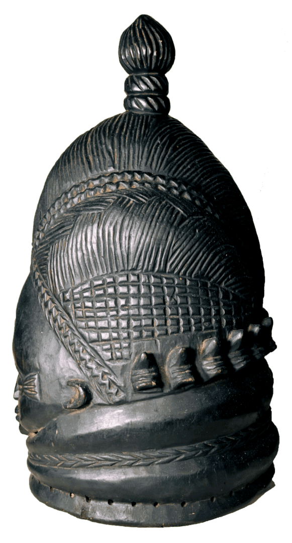 A dark, carved wooden mask with an elaborate, textured hairstyle, a woven patterned band, and a top-knot finial.