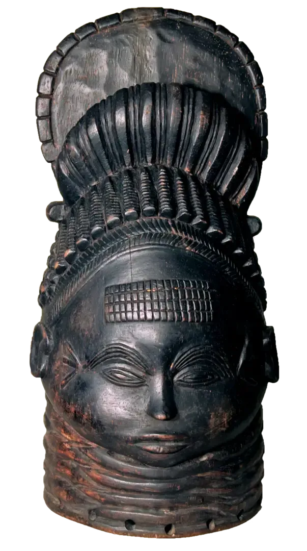 A dark, carved wooden Mende Sowei helmet mask with a tall, elaborate hairstyle, ridged neck, and serene facial features.