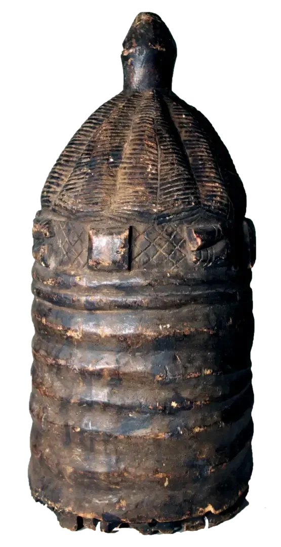 A dark, cylindrical wooden container or vessel featuring carved horizontal rings and a textured, dome-shaped lid.