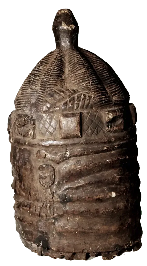 A cylindrical, dark-toned carved wooden container with a domed lid and intricate geometric and figurative relief patterns.