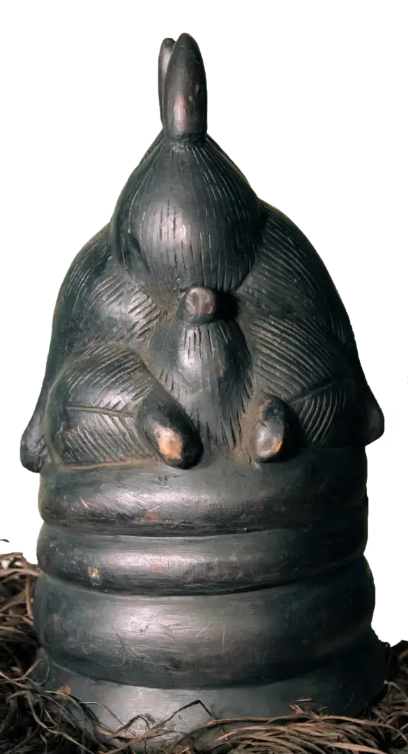 A dark, carved wooden vessel featuring a stylized, seated figure atop a base with tiered, ring-like horizontal bands.
