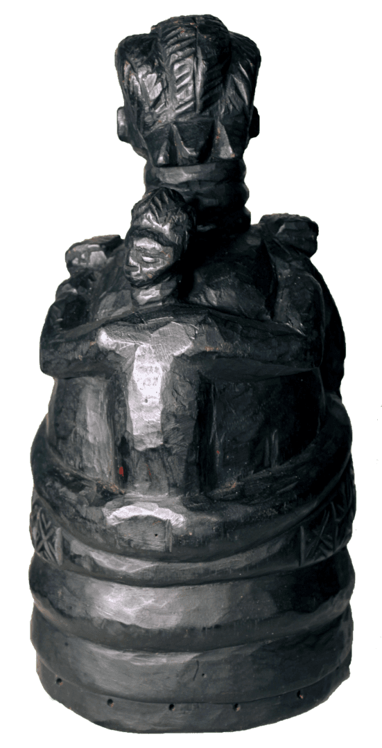 Dark, carved wooden sculpture featuring a central figure surrounded by smaller figures, set on a cylindrical base.