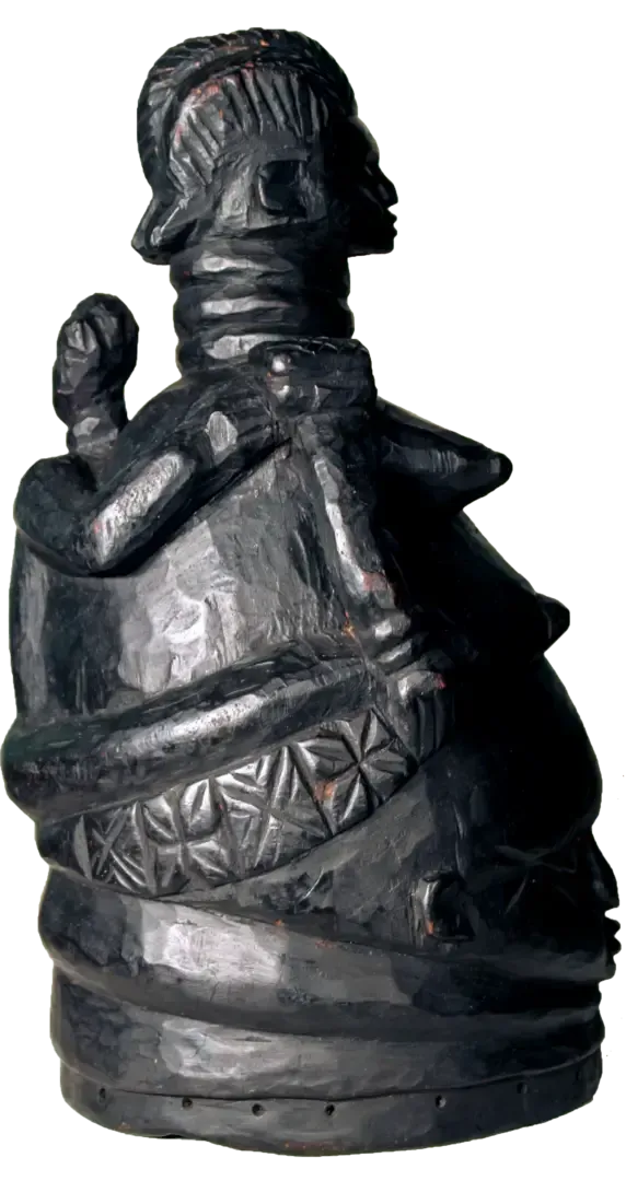 Dark, sculpted wooden figure with a ringed neck, carrying a smaller figure on its back, featuring intricate waist carvings.