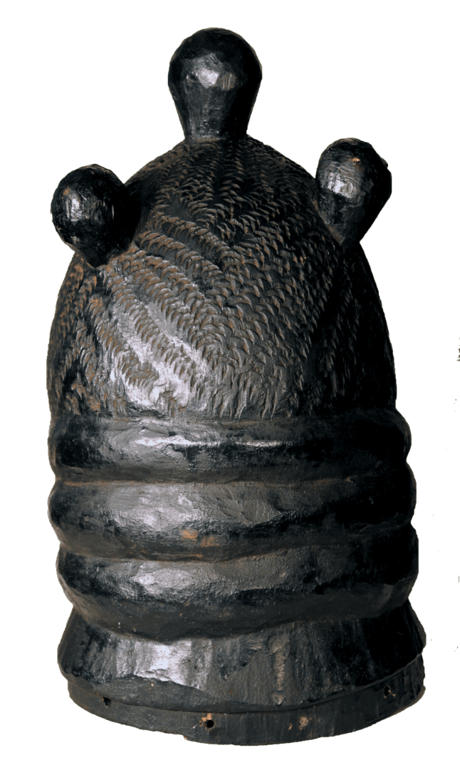 A dark, polished wooden headpiece featuring three rounded protrusions on top and textured, carved horizontal bands.