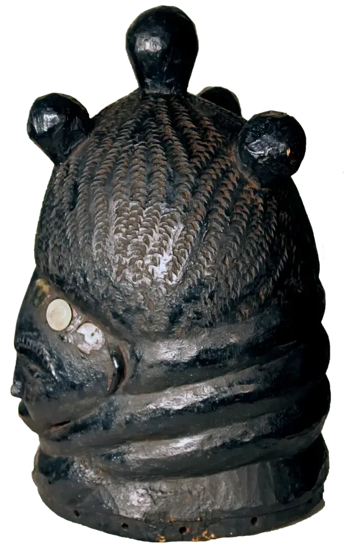 Black carved wooden mask with stylized braids, top knots, and inlaid shell or stone accents on the side.