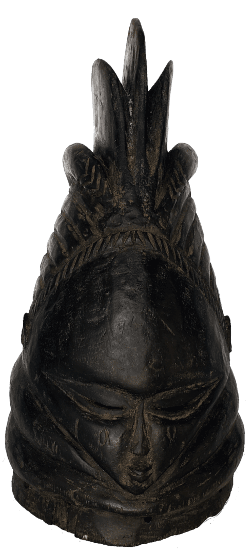 A dark-colored, hand-carved wooden sculpture featuring a serene human-like face topped with a tall, crested headdress.
