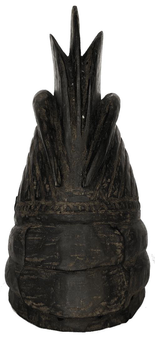 A dark, carved wooden finial with a pointed, crest-like top and horizontal ribbed bands at its base.