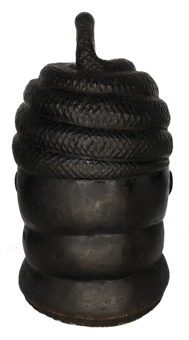 A black sculptural object resembling a beehive, with a coiled rope-like texture on top and smooth, rounded rings below.