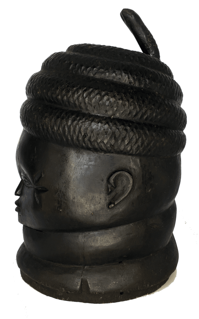 A black carved sculpture of a head wearing a coiled, textured headdress and a neck ring.