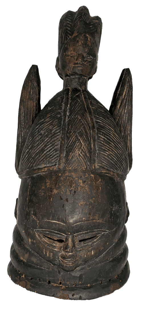 A dark brown, carved wooden Mende Sowei helmet mask with detailed coiffure, neck rings, and a small figure on top.