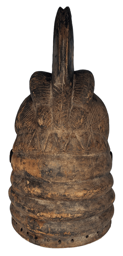 A carved wooden bell with a triangular-patterned band and a central arched handle, showing worn, dark-brown texture.