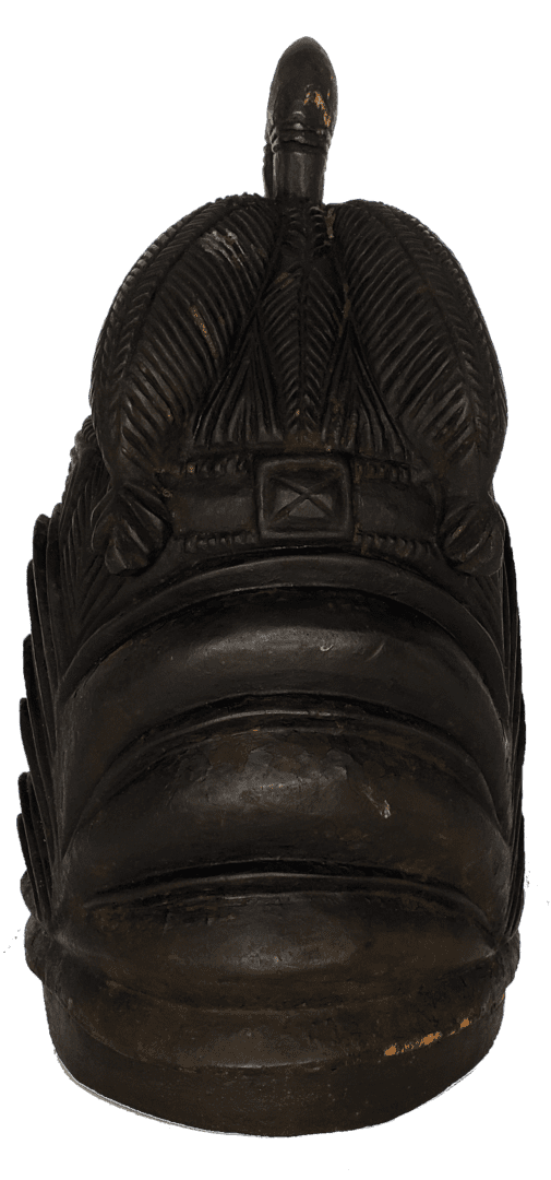 A black carved wooden head ornament with vertical, textured ridges and a central pointed top against a white background.