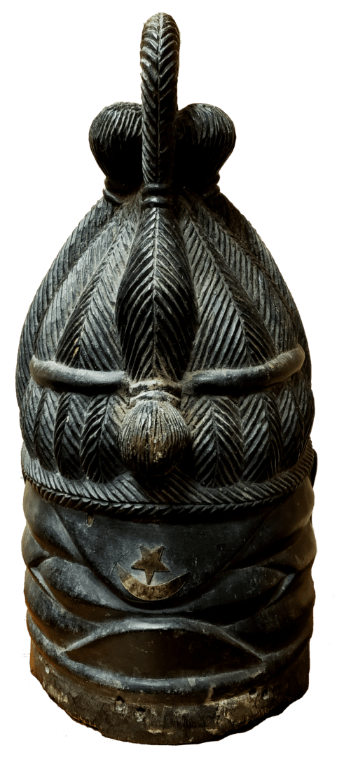A carved dark stone bell featuring intricate textured patterns and a prominent loop handle at the top.