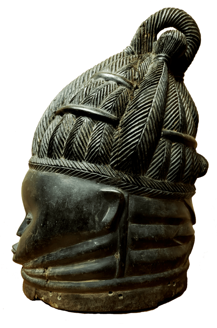 A dark, carved wooden mask with an intricate braided hairstyle and horizontal neck ridges against a plain background.
