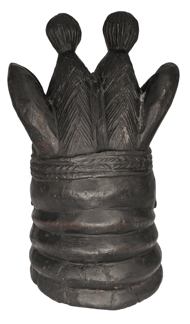 A dark, sculpted head-piece with stacked horizontal rings, two central textured conical forms, and side protrusions.