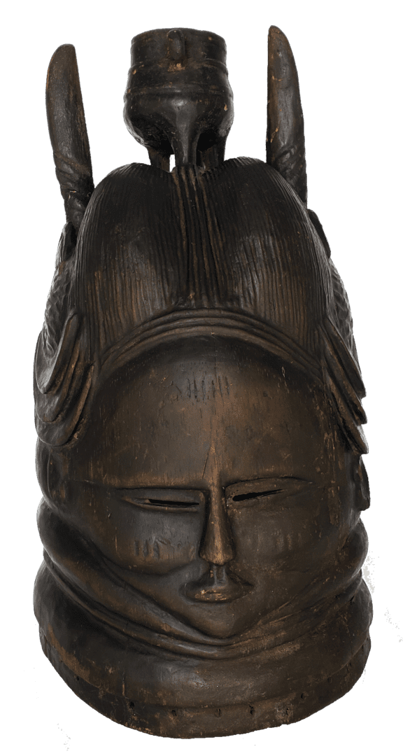 Dark wooden Mende helmet mask with carved facial features, elaborate hairstyle, and tall decorative projections.