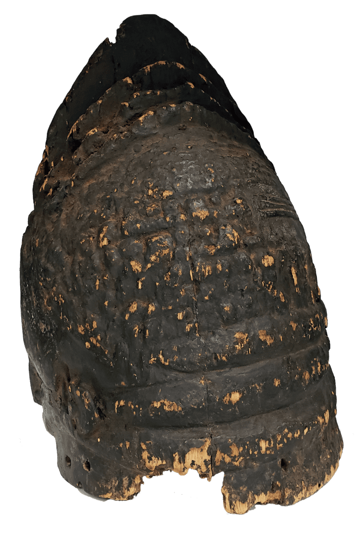 An ancient, dark leather helmet with a rounded dome, textured surface, and small holes around the bottom rim.