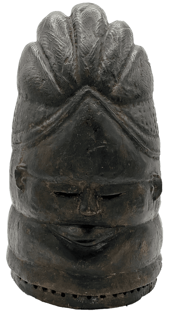 A dark, carved wooden head featuring a stylized, ribbed crest, small recessed eyes, and a horizontal band along the base.