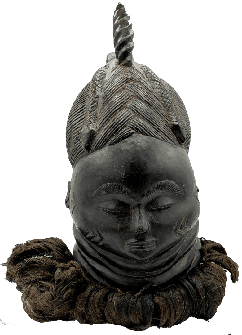 A dark, carved wooden helmet mask featuring an intricate braided hairstyle and a calm, downcast face with a raffia base.
