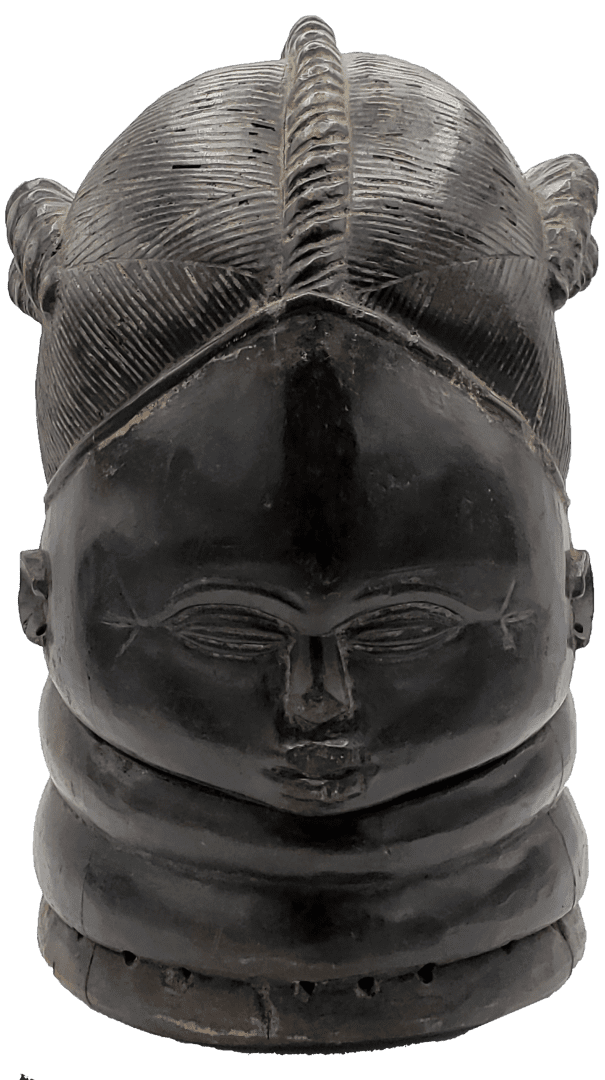 A dark wood carving of a stylized head with detailed, ridged hair, a prominent forehead, and multiple neck rings.