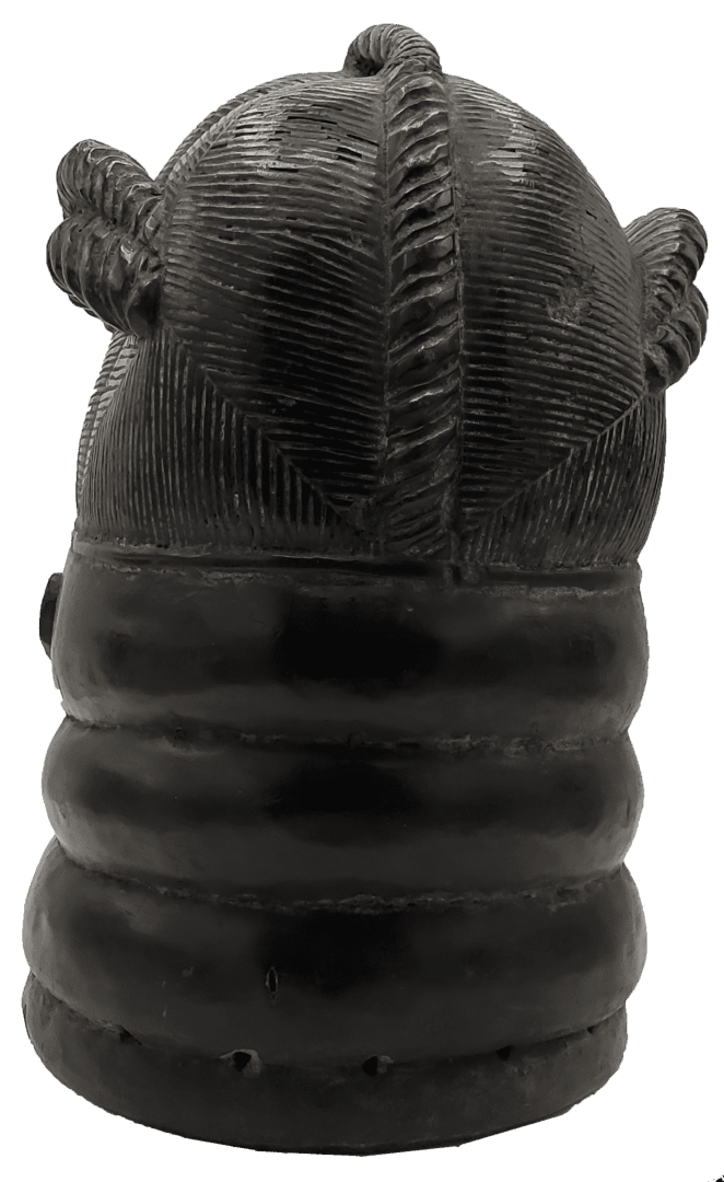 A black, carved wooden bust of a stylized head with detailed braided hair texture and prominent neck rings.