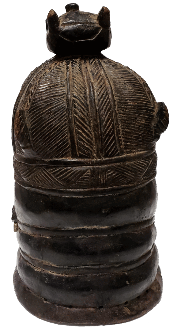 Dark brown carved wooden artifact, cylindrical with textured, geometric patterns on top and smooth, tiered lower bands.