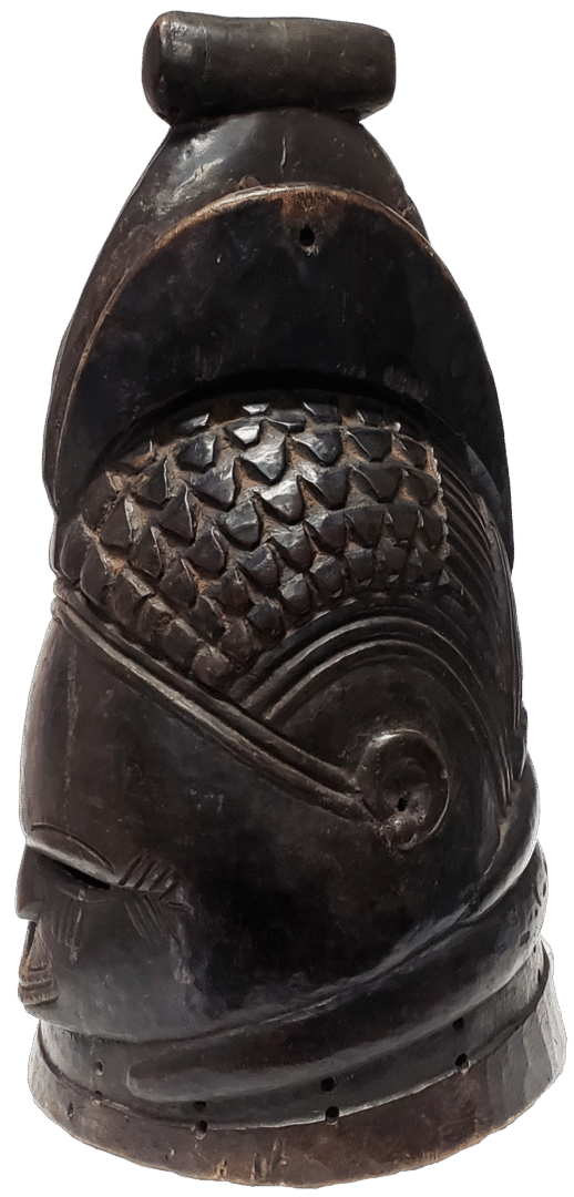 A carved, dark-brown wooden object featuring textured, scale-like patterns and curved decorative lines.