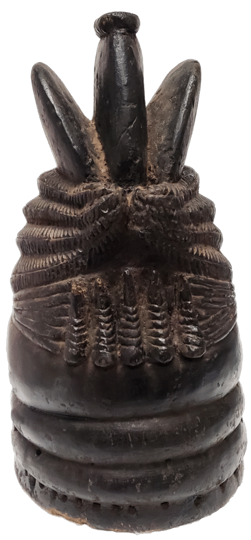 A carved, dark wooden object shaped like a pineapple or stylized bud, with horizontal ridges and vertical projections.