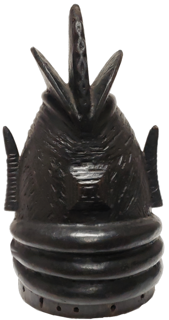 A dark, hand-carved wooden sculpture featuring an ornate, peaked crown with three ridges above a smooth circular base.