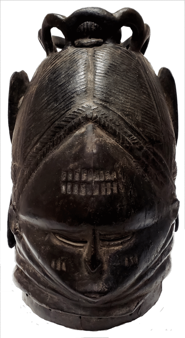A carved, dark wooden helmet mask with a serene facial expression, intricate hair detailing, and a sculptural top piece.