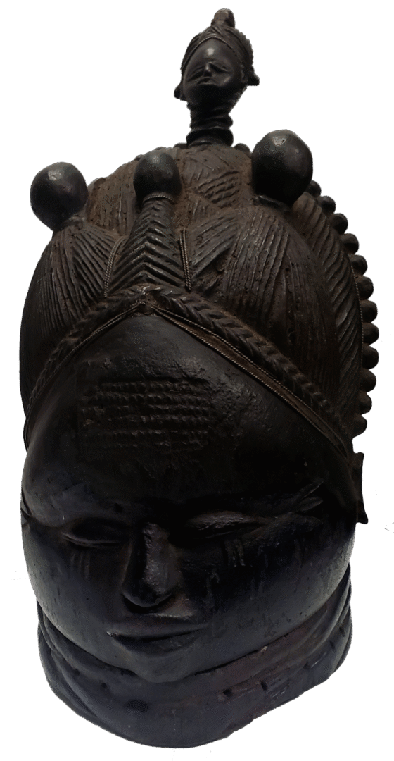 Dark, carved wooden helmet mask with an elaborate headdress featuring a small central figure and geometric patterns.