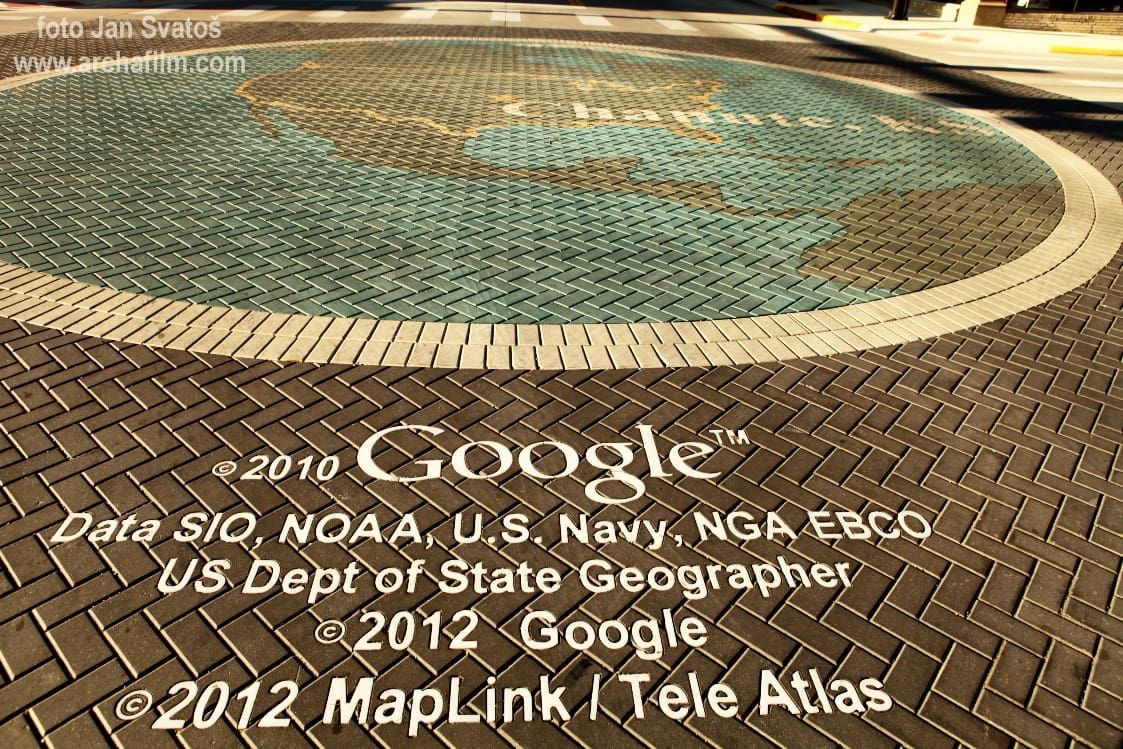 A map of North America rendered in mosaic tiles on a brick walkway, featuring overlaid 2012 Google map copyright text.