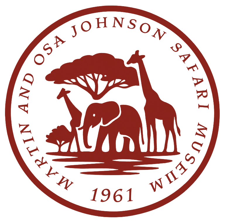 A circular logo for the Martin and Osa Johnson Safari Museum featuring an elephant, two giraffes, and a tree in red.