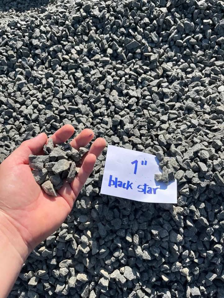 Hand holding black star gravel beside a sign labeled “1\