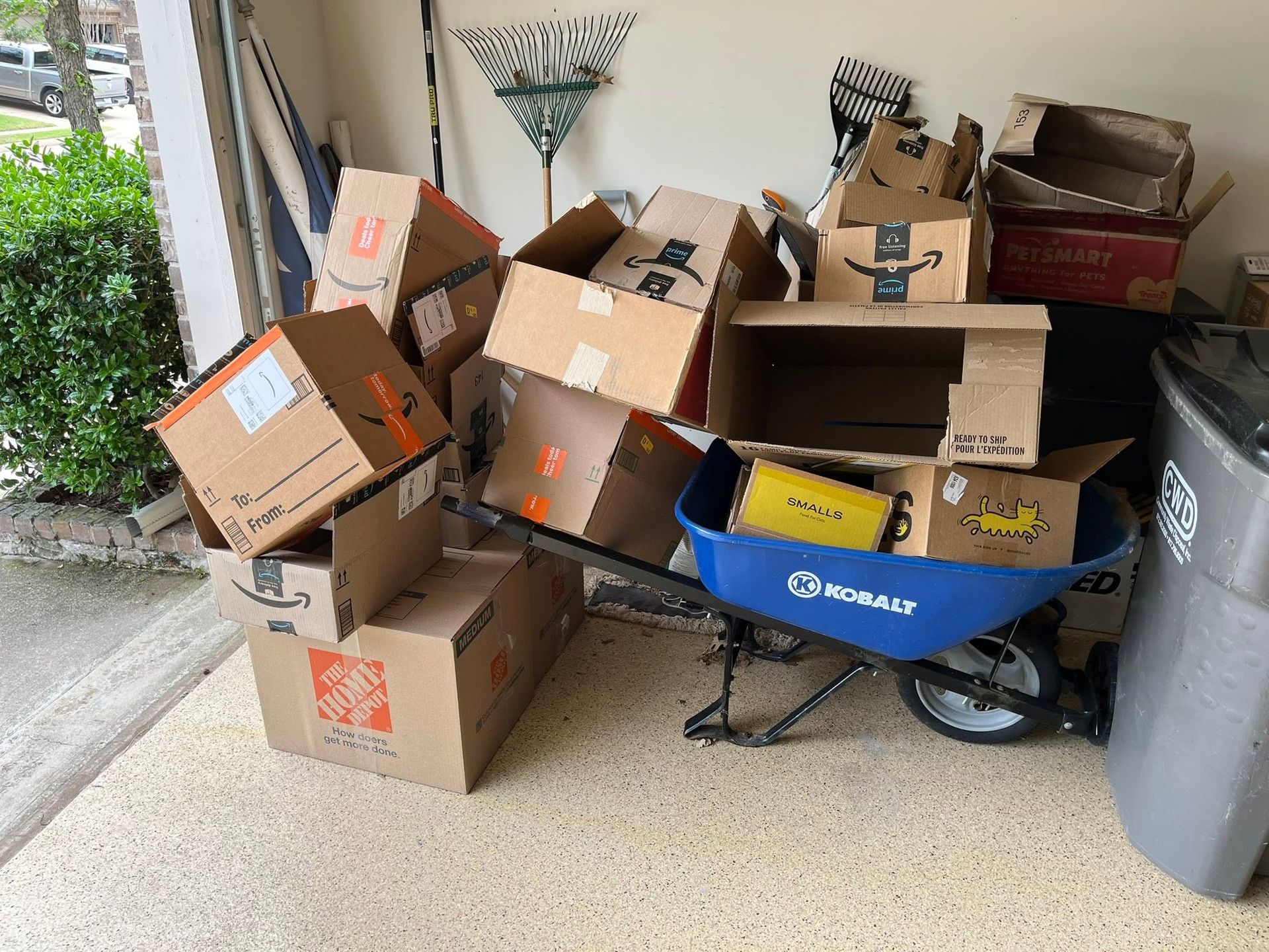 Pile of cardboard boxes and recycling bins cluttering a garage or storage area