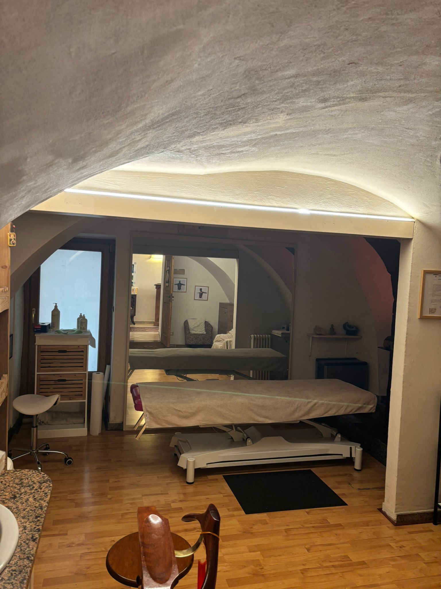 Accogliente camera da letto con soffitto a volta, letto e luci calde in un interno rustico.