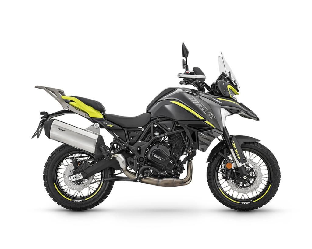 Motocicletta da avventura nera e gialla con pneumatici tassellati, su sfondo bianco.