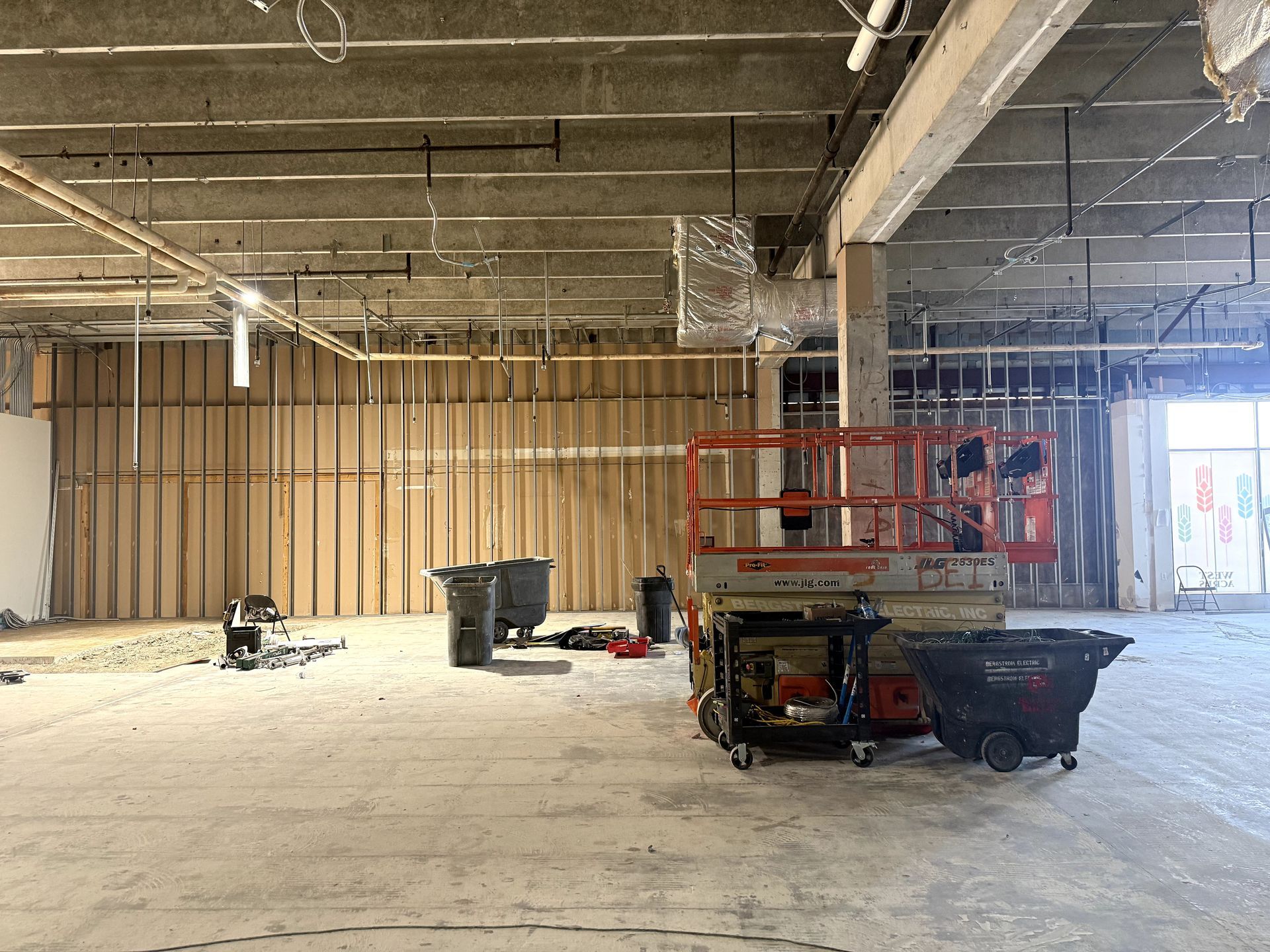 Room with freshly painted gray walls, unfinished floor, and a recessed ceiling light.
