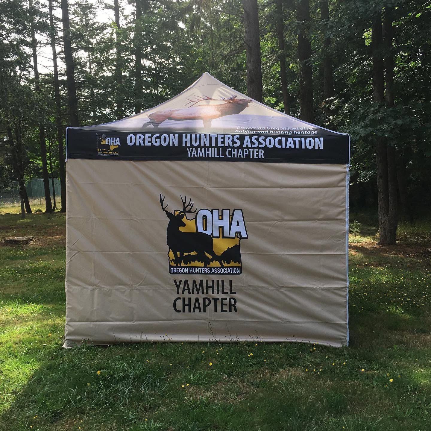 Oregon Hunters Association Yamhill Chapter pop-up tent in a wooded outdoor setting