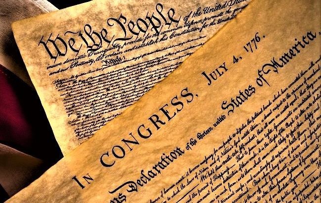 Close-up of the U.S. Constitution and Declaration of Independence on aged parchment.