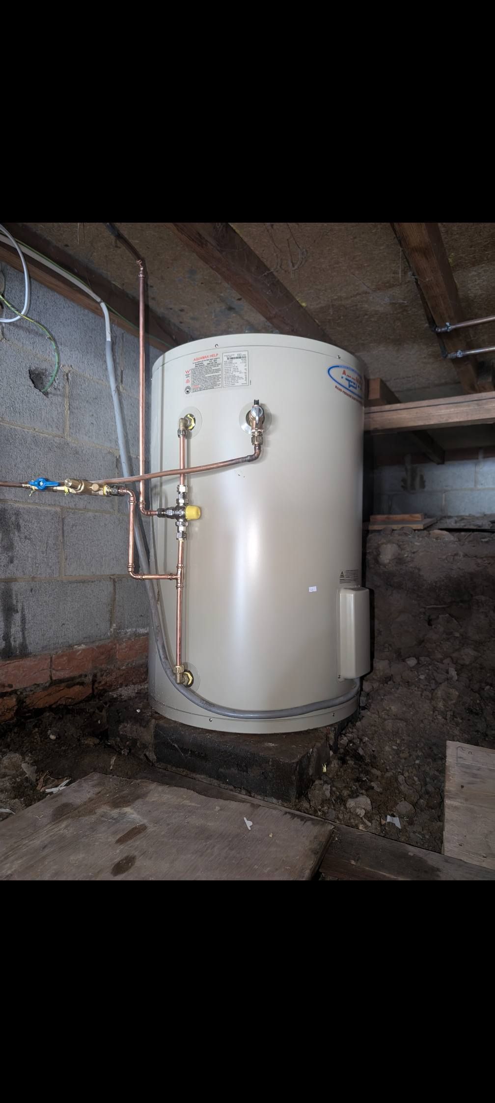 A Beige Residential Water Heater Installed in a Dark — TasWide Plumbing in Kingston, TAS