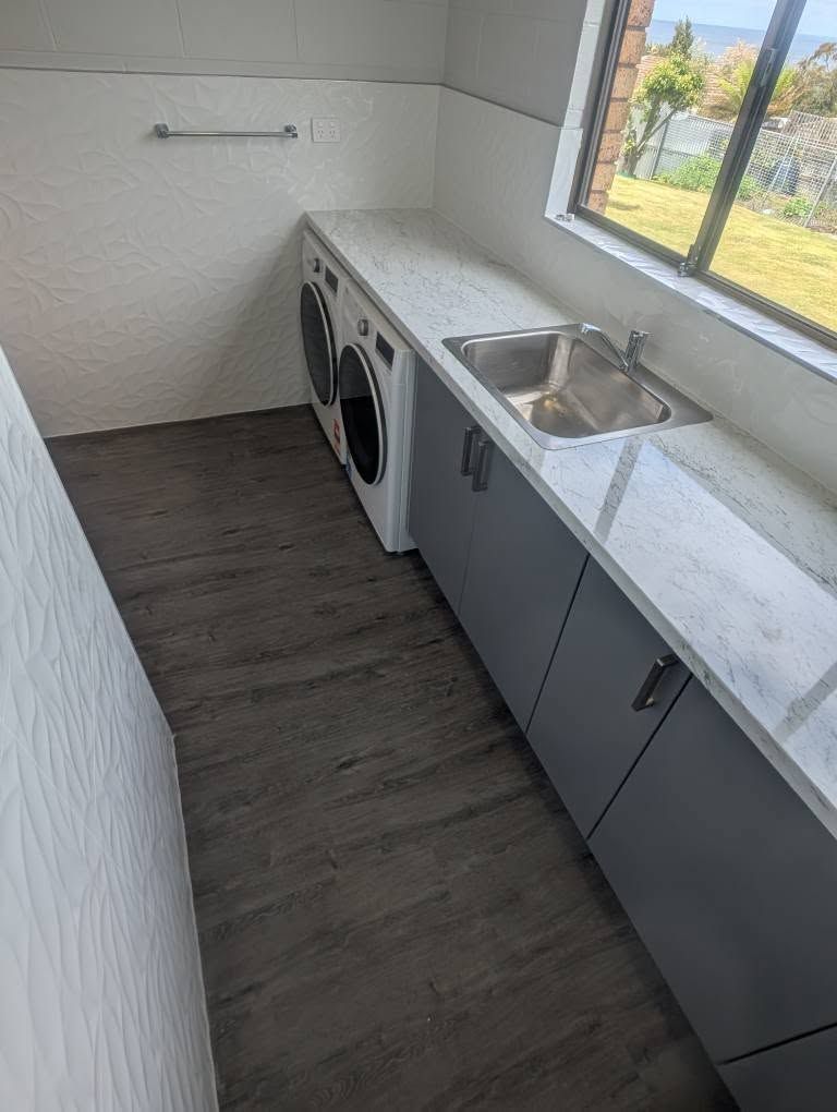 A Laundry Room Featuring Gray Cabinets, a White Marble Countertop — TasWide Plumbing in Kingston, TAS