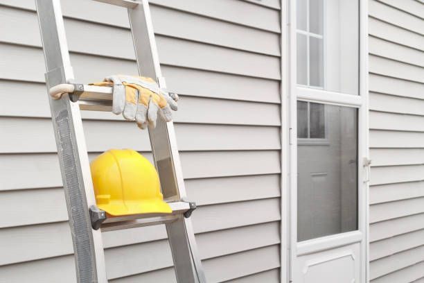 A ladder rests in Lancaster, NY, adorned with a hard hat and gloves, representing HomeTeck Roofing & Remodeling's services.